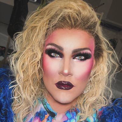 Abby in blue feathers and blonde curls (opens Instagram)